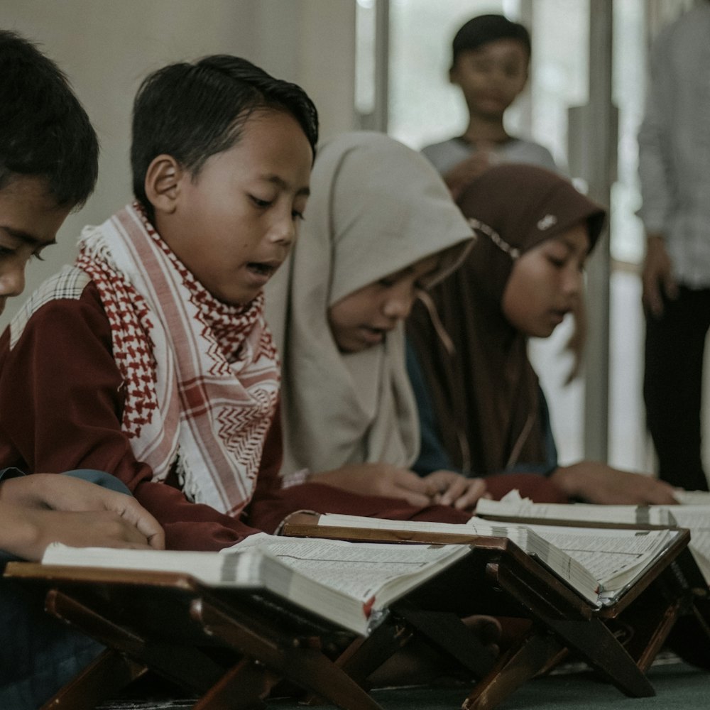 Santri laki-laki membaca Al-Qur'an di atas rehal
